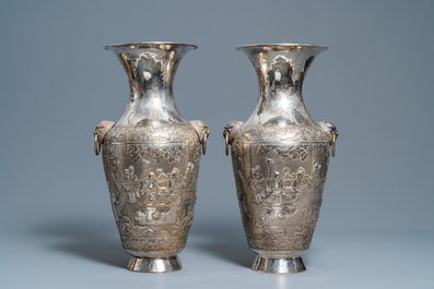 A pair of exceptional large Chinese relief-decorated silver vases, 19th C.