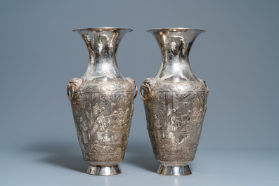 A pair of exceptional large Chinese relief-decorated silver vases, 19th C.