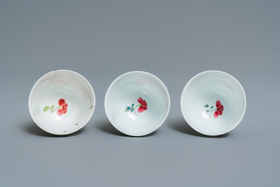 Three Chinese famille rose cups and saucers with figures in a garden, Yongzheng