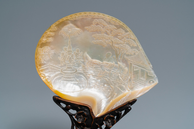 A pair of Chinese carved mother-of-pearl shells on wooden stands, 19th C.