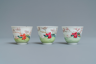 Three Chinese famille rose cups and saucers with figures in a garden, Yongzheng