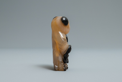 A Chinese carved agate snuff bottle in the shape of a boy, 19/20th C.