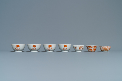 Fourteen Chinese iron-red and gilt cups and nine saucers, Kangxi/Qianlong