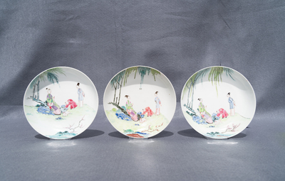 Three Chinese famille rose cups and saucers with figures in a garden, Yongzheng