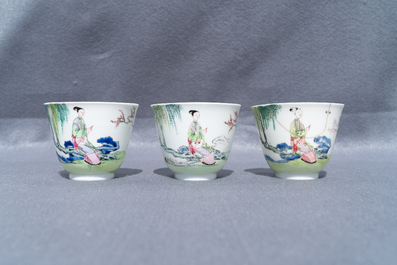 Three Chinese famille rose cups and saucers with figures in a garden, Yongzheng