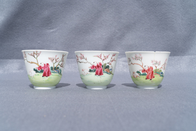 Three Chinese famille rose cups and saucers with figures in a garden, Yongzheng