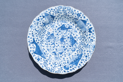 Un grand plat godronn&eacute; en porcelaine de Chine en bleu et blanc &agrave; d&eacute;cor de poissons, Chine, Kangxi