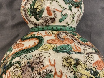 A Chinese famille verte relief-moulded double gourd 'dragon' vase on wooden stand, 19/20th C.