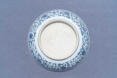 Un plat en porcelaine de Chine en bleu et blanc &agrave; d&eacute;cor de rinceaux floraux de style Ming, Qianlong