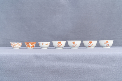 Fourteen Chinese iron-red and gilt cups and nine saucers, Kangxi/Qianlong