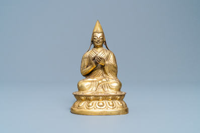 A Sino-Tibetan gilt bronze figure of a Lama, Ming