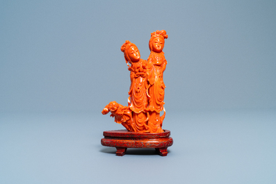 A Chinese carved red coral group of two ladies and a child, 19/20th C.