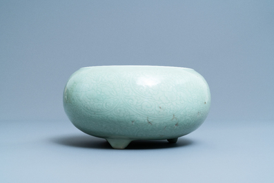 Een Chinese monochrome celadon driepotige wierookbrander met onderglazuur floraal decor, Kangxi