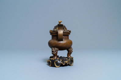 A Chinese bronze tripod censer with 'lotus leaf' cover and stand, 17/18th C.