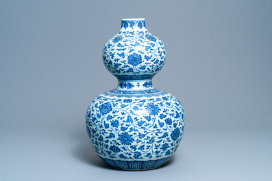 A large Chinese blue and white double gourd vase with floral scrolls, 19/20th C.