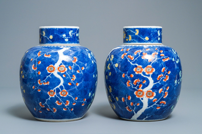 A pair of Chinese polychrome 'prunus on cracked ice' jars and covers, 19th C.