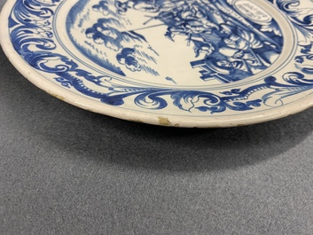 A Dutch Delftware blue and white dish with soldiers at camp, Makkum, dated 1764