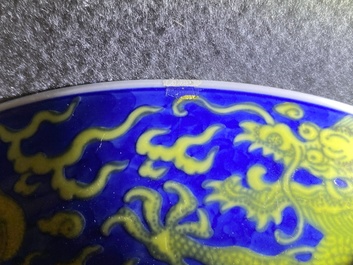 Un plat en porcelaine de Chine en bleu et jaune &agrave; d&eacute;cor d'un dragon, marque et &eacute;poque de Qianlong