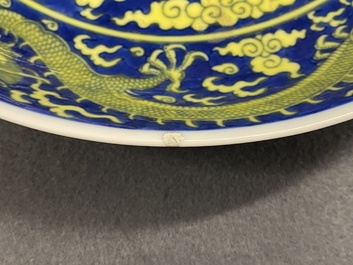 Un plat en porcelaine de Chine en bleu et jaune &agrave; d&eacute;cor d'un dragon, marque et &eacute;poque de Qianlong