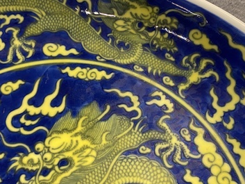 Un plat en porcelaine de Chine en bleu et jaune &agrave; d&eacute;cor d'un dragon, marque et &eacute;poque de Qianlong