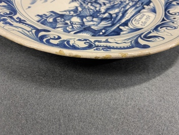 A Dutch Delftware blue and white dish with soldiers at camp, Makkum, dated 1764