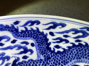 Un plat en porcelaine de Chine en bleu et blanc &agrave; d&eacute;cor d'un dragon, marque et &eacute;poque de Kangxi