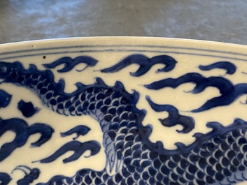 Un plat en porcelaine de Chine en bleu et blanc &agrave; d&eacute;cor d'un dragon, marque et &eacute;poque de Kangxi