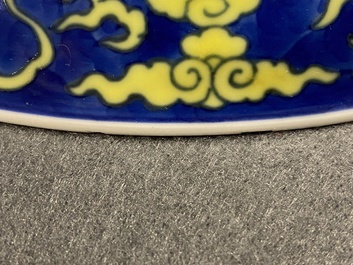 Un plat en porcelaine de Chine en bleu et jaune &agrave; d&eacute;cor d'un dragon, marque et &eacute;poque de Qianlong