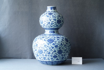 A large Chinese blue and white double gourd vase with floral scrolls, 19/20th C.