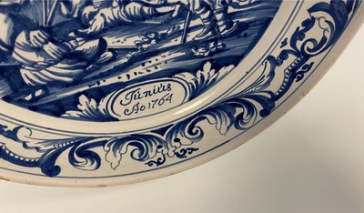 A Dutch Delftware blue and white dish with soldiers at camp, Makkum, dated 1764