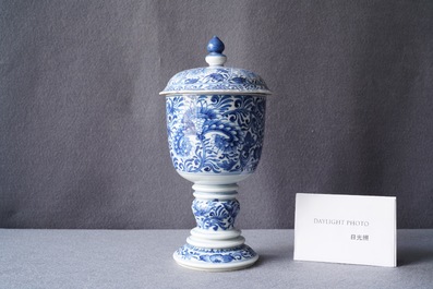 Een Chinese blauw-witte dekselbeker met floraal decor, Kangxi