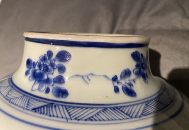 A pair of Chinese blue and white baluster vases and covers with birds in a rocky setting, Kangxi