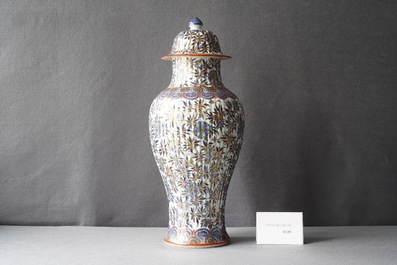 A Chinese blue and white clobbered vase and cover with floral design, Kangxi