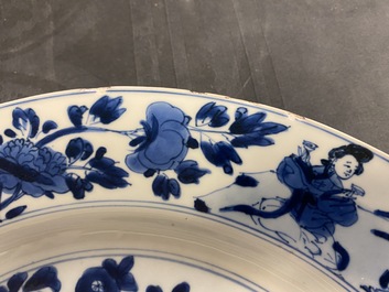 Een Chinese blauw-witte schotel met dames bij een jardini&egrave;re, Kangxi