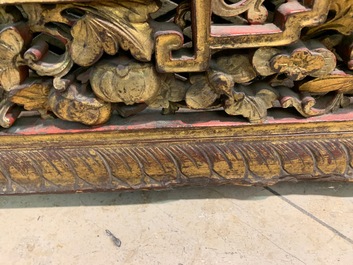 A Chinese carved and gilt wooden panel with red painted characters, 18/19th C.