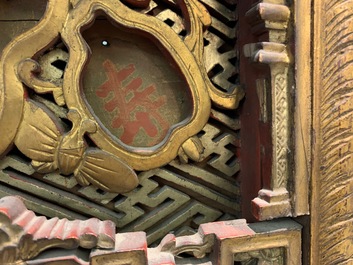 A Chinese carved and gilt wooden panel with red painted characters, 18/19th C.