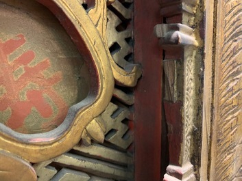 A Chinese carved and gilt wooden panel with red painted characters, 18/19th C.