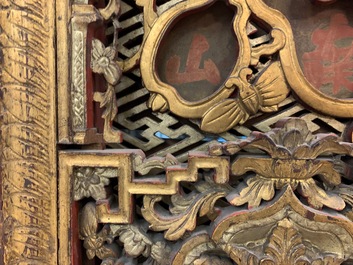 A Chinese carved and gilt wooden panel with red painted characters, 18/19th C.