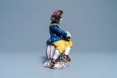 A polychrome Dutch Delft figure of a hurdy-gurdy player, 18th C.