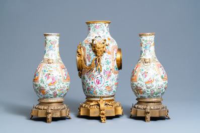 Une garniture de trois pi&egrave;ces en porcelaine de Chine famille rose de Canton mont&eacute;e en pendule en bronze dor&eacute;, 19&egrave;me