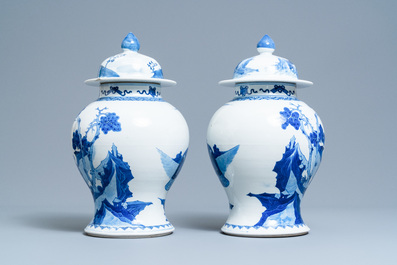 A pair of Chinese blue and white vases and covers with figures in a landscape, 19th C.