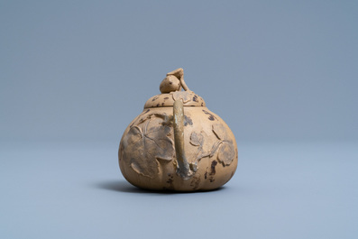 A bichrome Chinese Yixing stoneware teapot and cover with applied floral design, 19th C.