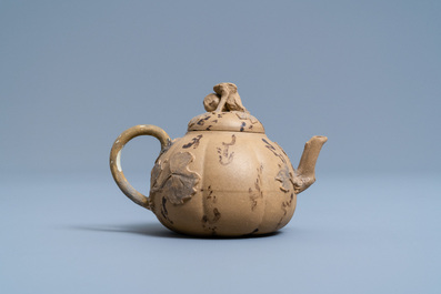 A bichrome Chinese Yixing stoneware teapot and cover with applied floral design, 19th C.