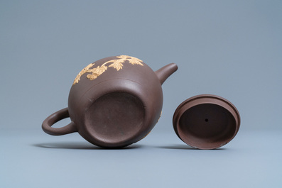 A bichrome Chinese Yixing stoneware teapot and cover with applied floral design, Kangxi