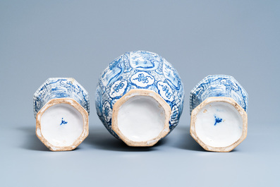 A Dutch Delft blue and white garniture of three vases and covers, 18th C.