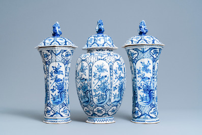 A Dutch Delft blue and white garniture of three vases and covers, 18th C.