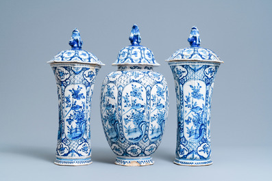 A Dutch Delft blue and white garniture of three vases and covers, 18th C.