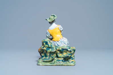 A polychrome Dutch Delft figure of a seated lady, 18th C.