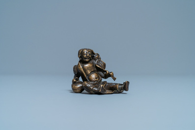 A Chinese bronze 'Liu Hai' scroll weight on wooden stand, Ming