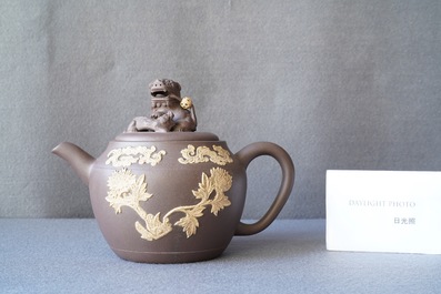 A bichrome Chinese Yixing stoneware teapot and cover with applied floral design, Kangxi